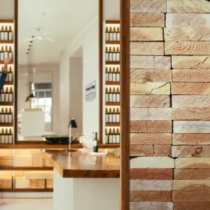 A realistic stacked timber design digitally printed on PVC-free Vescom Porak recycled textile wallcovering.