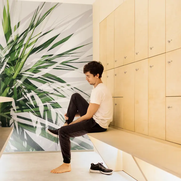 Vescom custom digital print wallcovering with a large-scale leaf design in a contemporary locker room interior.