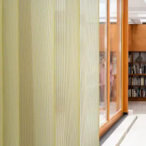 Acoustic Vescom Formoza sheer curtain with a green vertical accent yarn, providing transparency in a library setting.