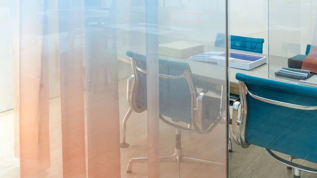 Transparent Vescom Airy curtain with a blue and orange gradient, creating a soft color wash in a modern office space.