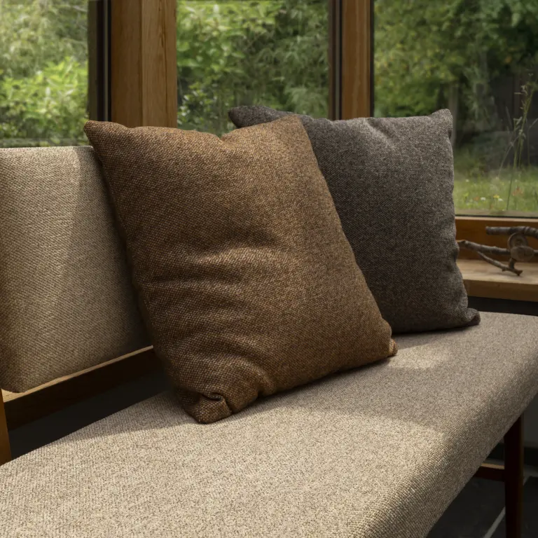 Neutral Vescom Bosco upholstery on a lounge chair surrounded by woodland textures.