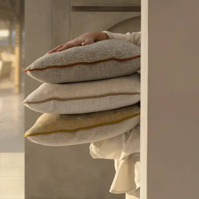 Laguna upholstery fabric by Vescom on outdoor seating with textured, crafted appearance held by person