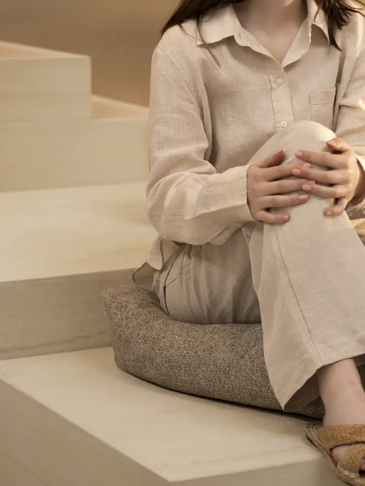 Laguna upholstery fabric by Vescom on upholstered seating with natural appearance and person sitting on fabric