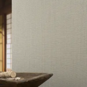 Vescom Birch woven textile wallcovering with subtle slub texture and architectural grid behind a wooden bowl on a table