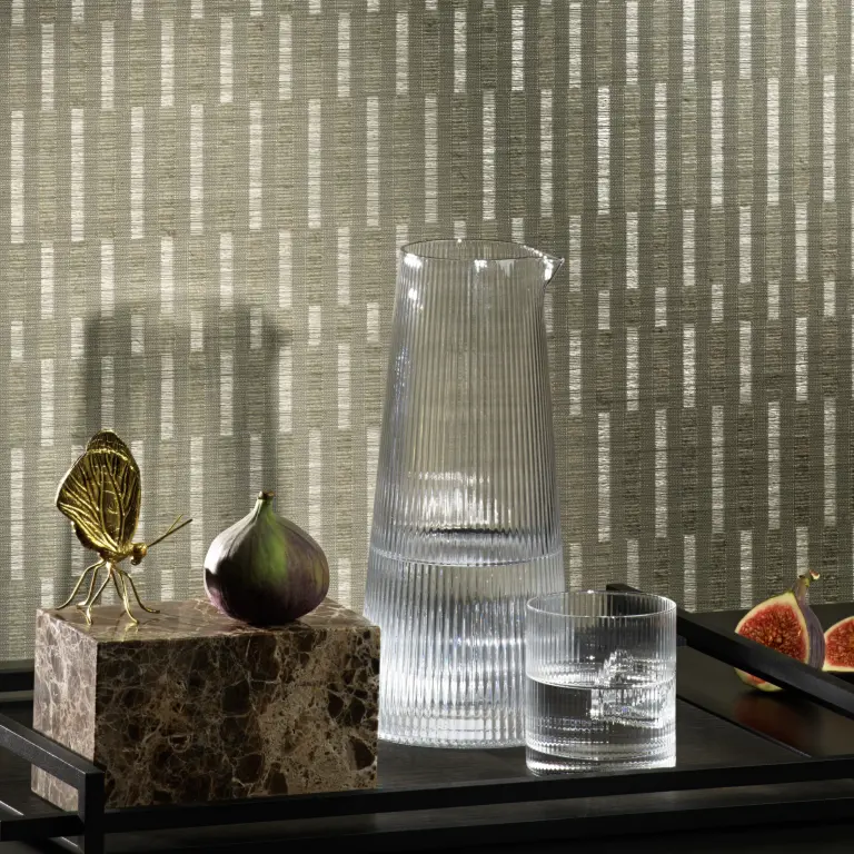 Vescom Fiero textile wallcovering featuring a refined vertical pattern, styled interior scene with glass carafe, marble object and figs