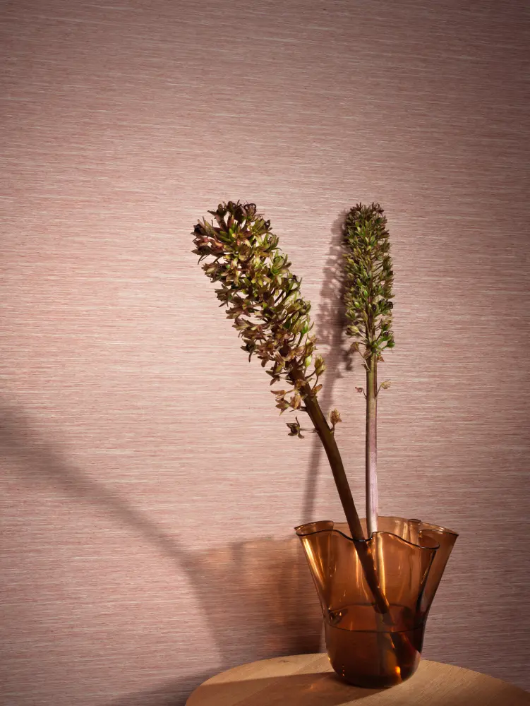 escom Ilara textile wallcovering with a crafted horizontal woven texture and subtle tonal variation, shown on interior walls in a styled setting with a glass vase and floral stems