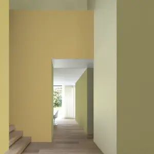 Vescom Colour Choice Mellow Ochre vinyl wallcovering in an interior with warm yellow tones and natural light