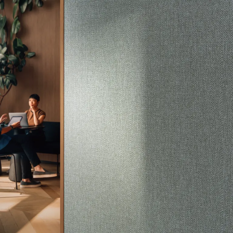 Vescom Harrison vinyl wallcovering with a deep herringbone texture, shown as a grounding surface in an interior setting.