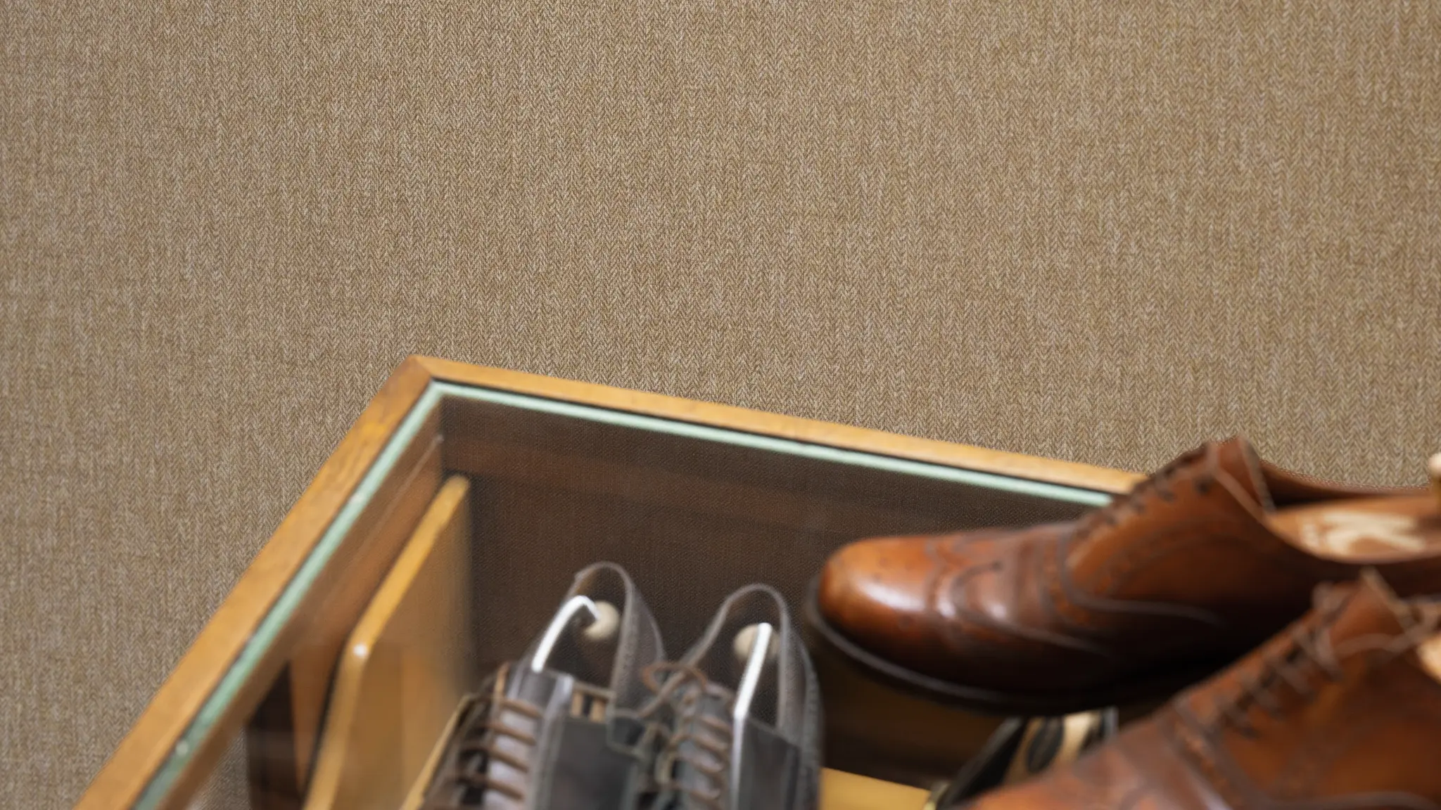 Vescom Harrison vinyl wallcovering in a warm hospitality setting with rich herringbone texture and soft lighting.