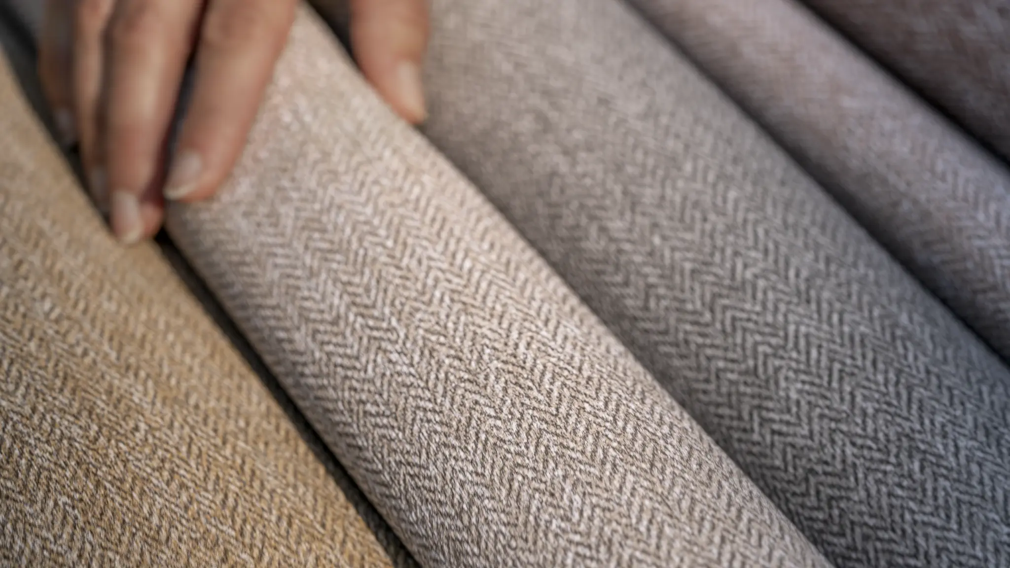 Close-up of Vescom Harrison vinyl wallcovering showing its refined herringbone pattern and tactile woollen look.