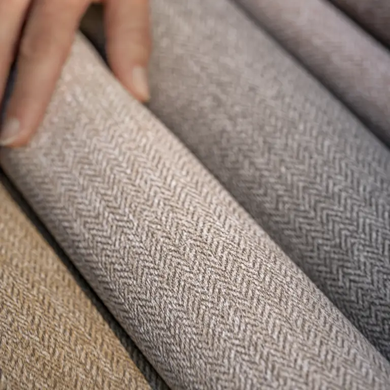 Close-up of Vescom Harrison vinyl wallcovering showing its refined herringbone pattern and tactile woollen look.