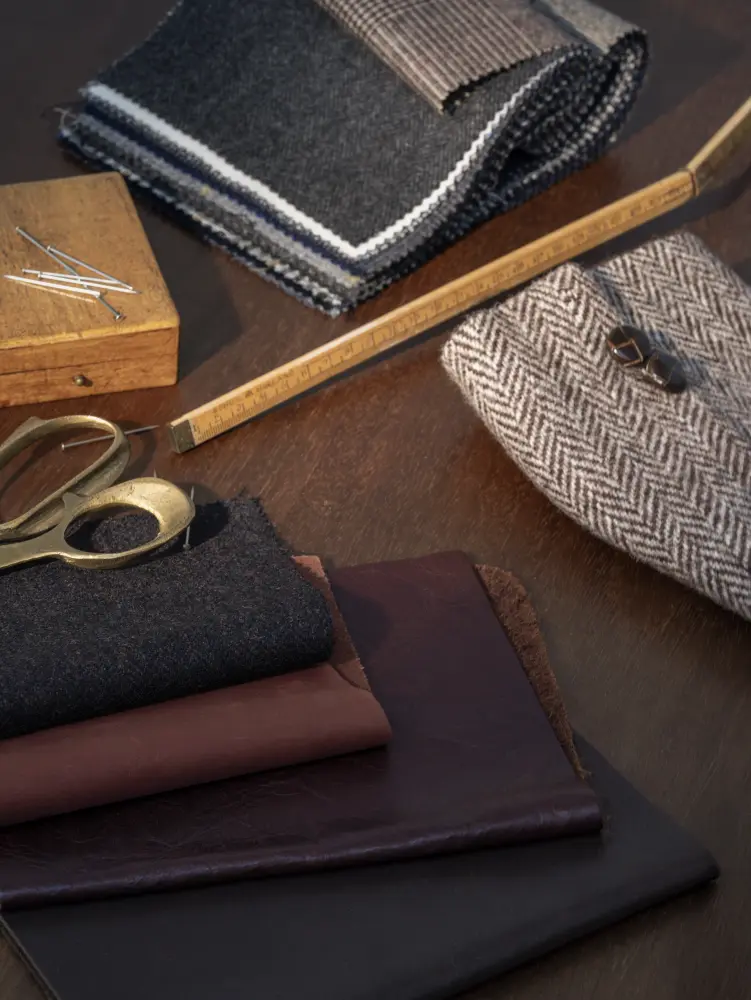 Vescom Harrison inspiration image showing tailoring tools, dark fabrics and herringbone textures linked to suit making.