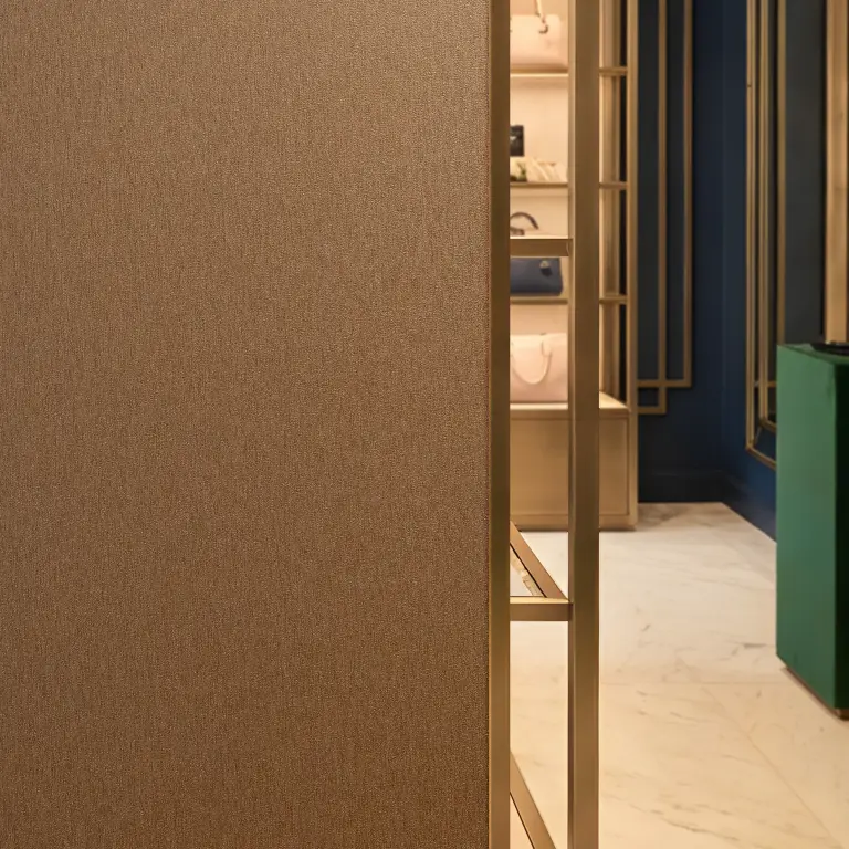 Vescom Stellar wallcovering detail showing a warm brushed metal look in an interior setting.