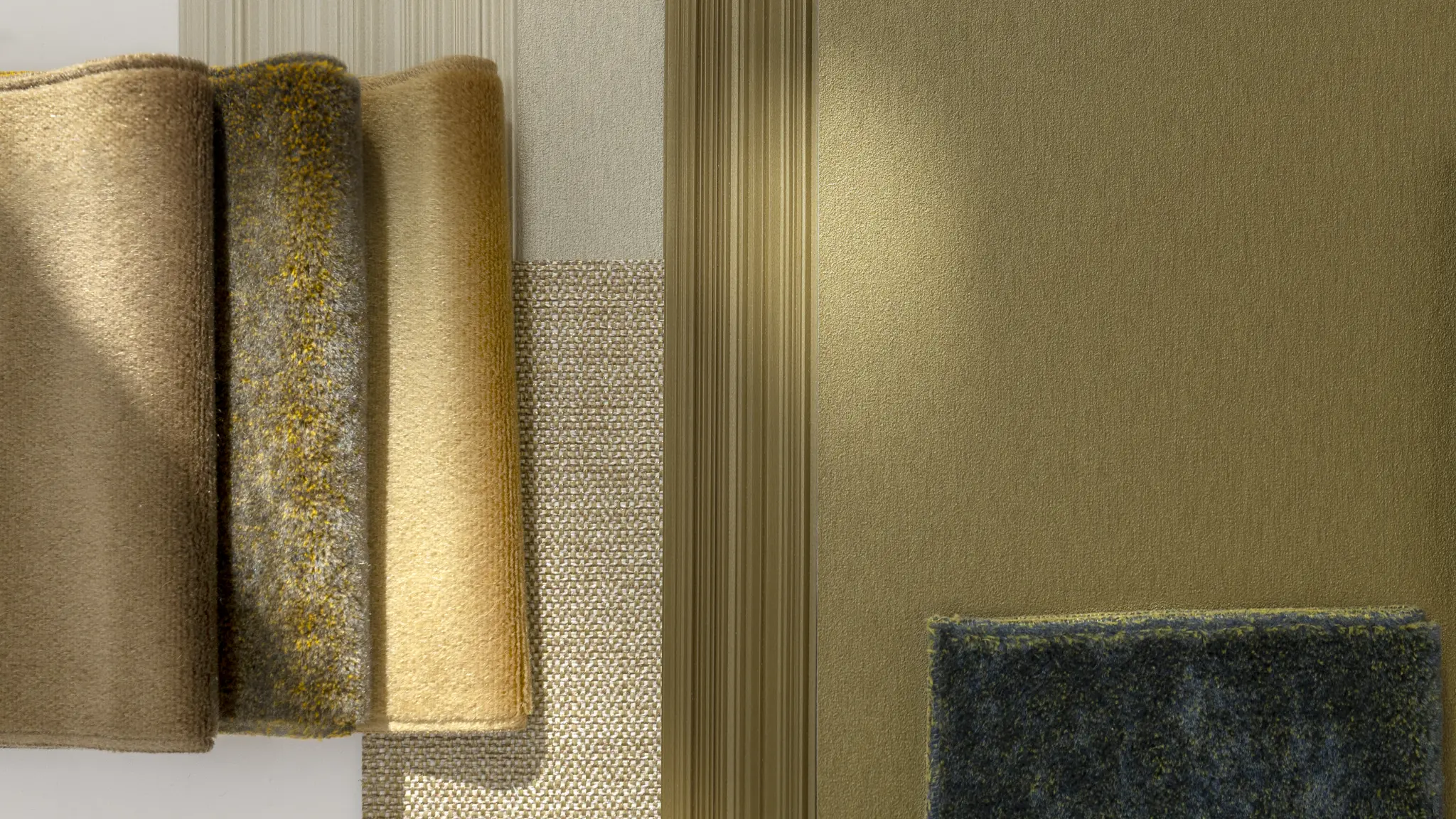 Vescom Stellar wallcovering samples in a luminous material palette with gold, bronze and soft neutral shades.