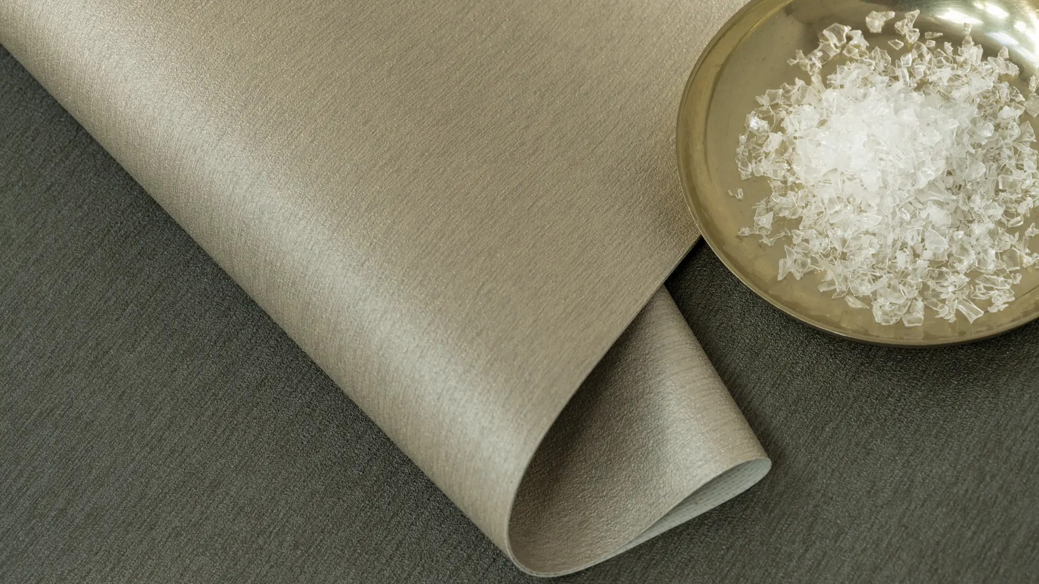 Vescom Stellar wallcovering sample with shredded plastic medical waste, highlighting recycled content in the material.